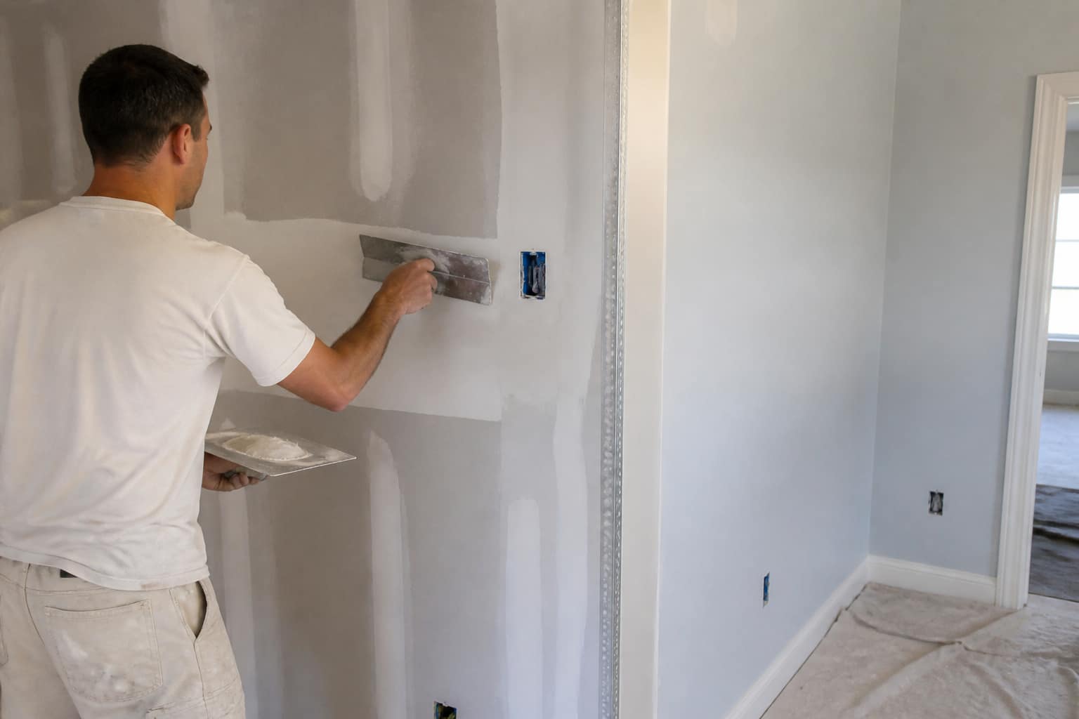 Drywall finishing compound being worked on an interior wall