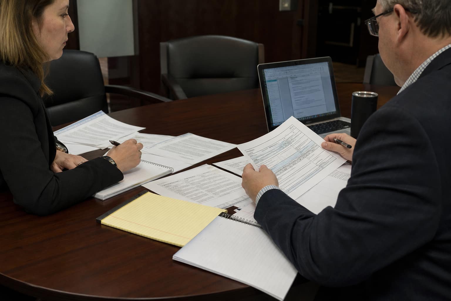Professionals reviewing documents at a meeting table